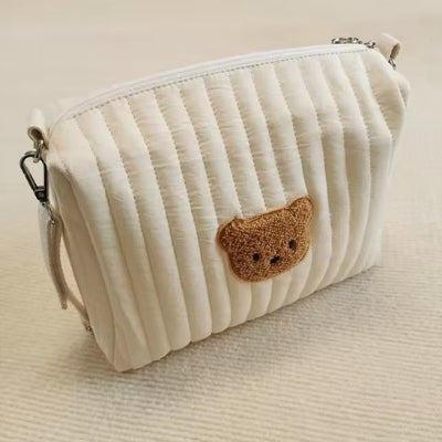 Trousse de toilette bébé déposé sur surface en tissue