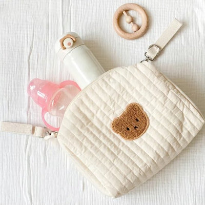 Trousse de toilette bébé ouverte avec biberon et hochet